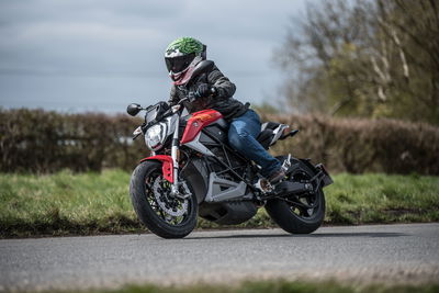 Zero Motorcycles SR/F with rider wear Joker Ruroc ATLAS 4.0 helmet, black leather jacket, blue riding jeans and brown riding boots.