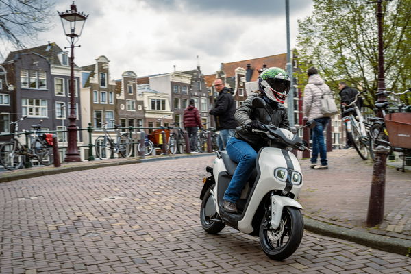 Yamaha NEO's riding through an urban area. Ride wearing blue riding jeans and black, leather riding jacket and Joker Ruroc ATLAS 4.0 helmet.