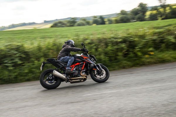 A KTM being ridden along a country lane