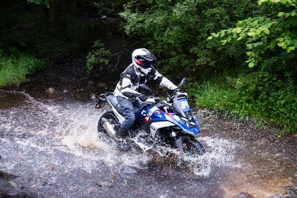 A motorcycle being ridden through a river crossing