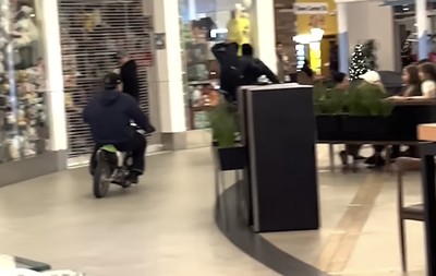 Dirt bikes ride through a busy shopping mall