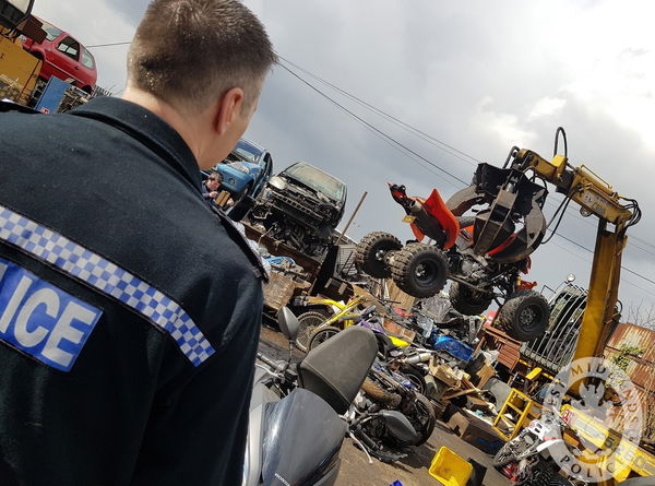A Police officer watching nuisance motorcycles and quad bikes being crushed