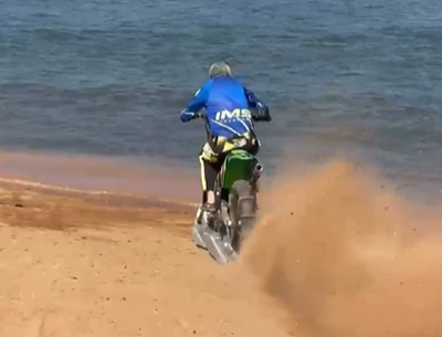 Motocross rider goes surfing on his motorcycle