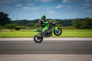 JD Stunts pulling a wheelie while seated on the handlebars