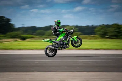 JD Stunts pulling a wheelie while seated on the handlebars