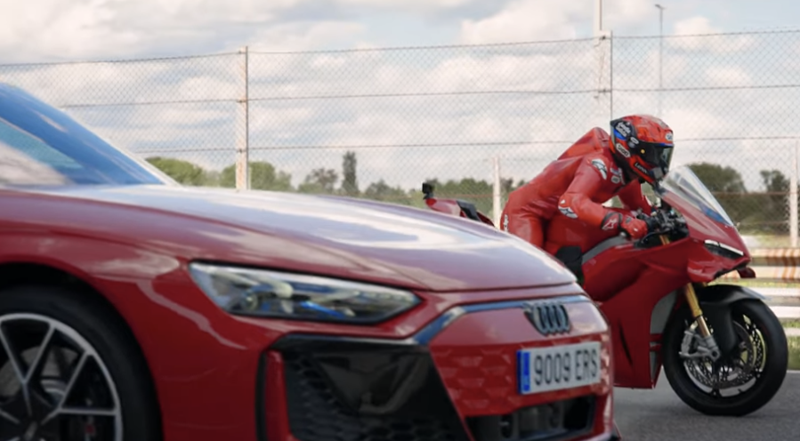 Marc Marquez lining up against an Audi on his Ducati Panigale V4 S