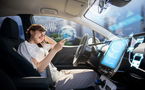 A driver at the wheel of a self-driving car