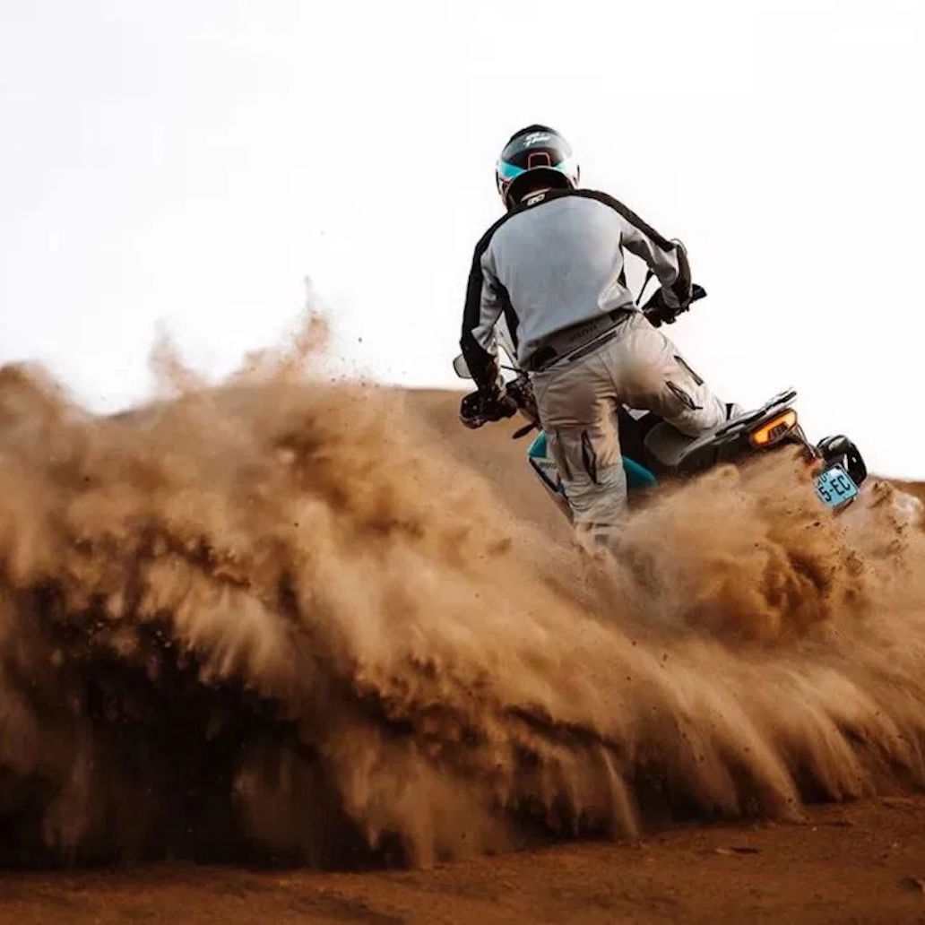 A CFMoto adventure bike riding in the sand