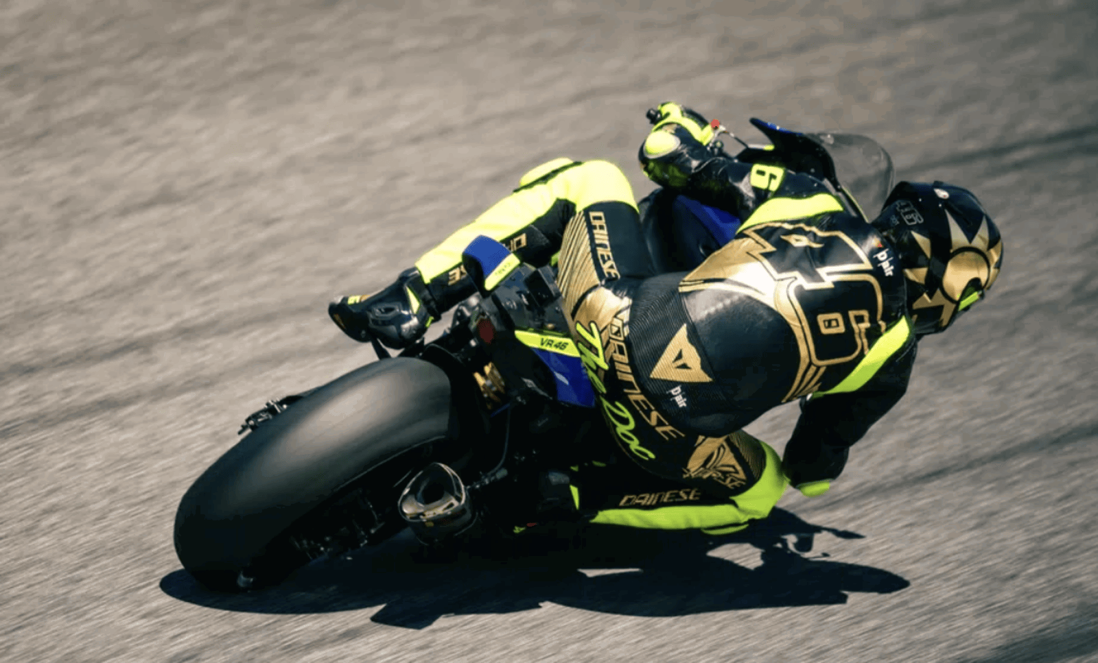 Valentino Rossi wearing a race suit and helmet. Photo credit - Dainese