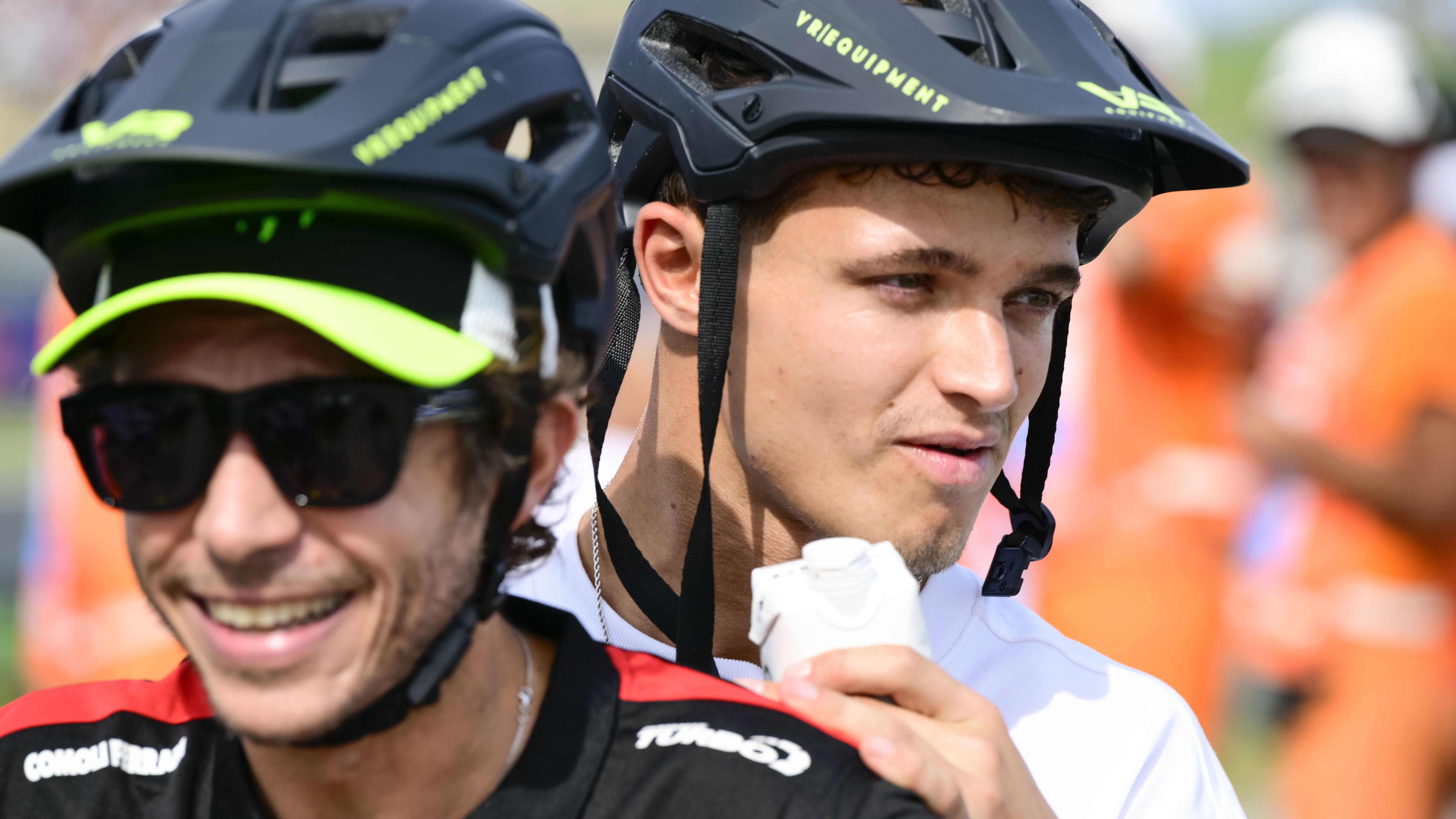 Lando Norris on the back of a scooter ridden by Valentino Rossi