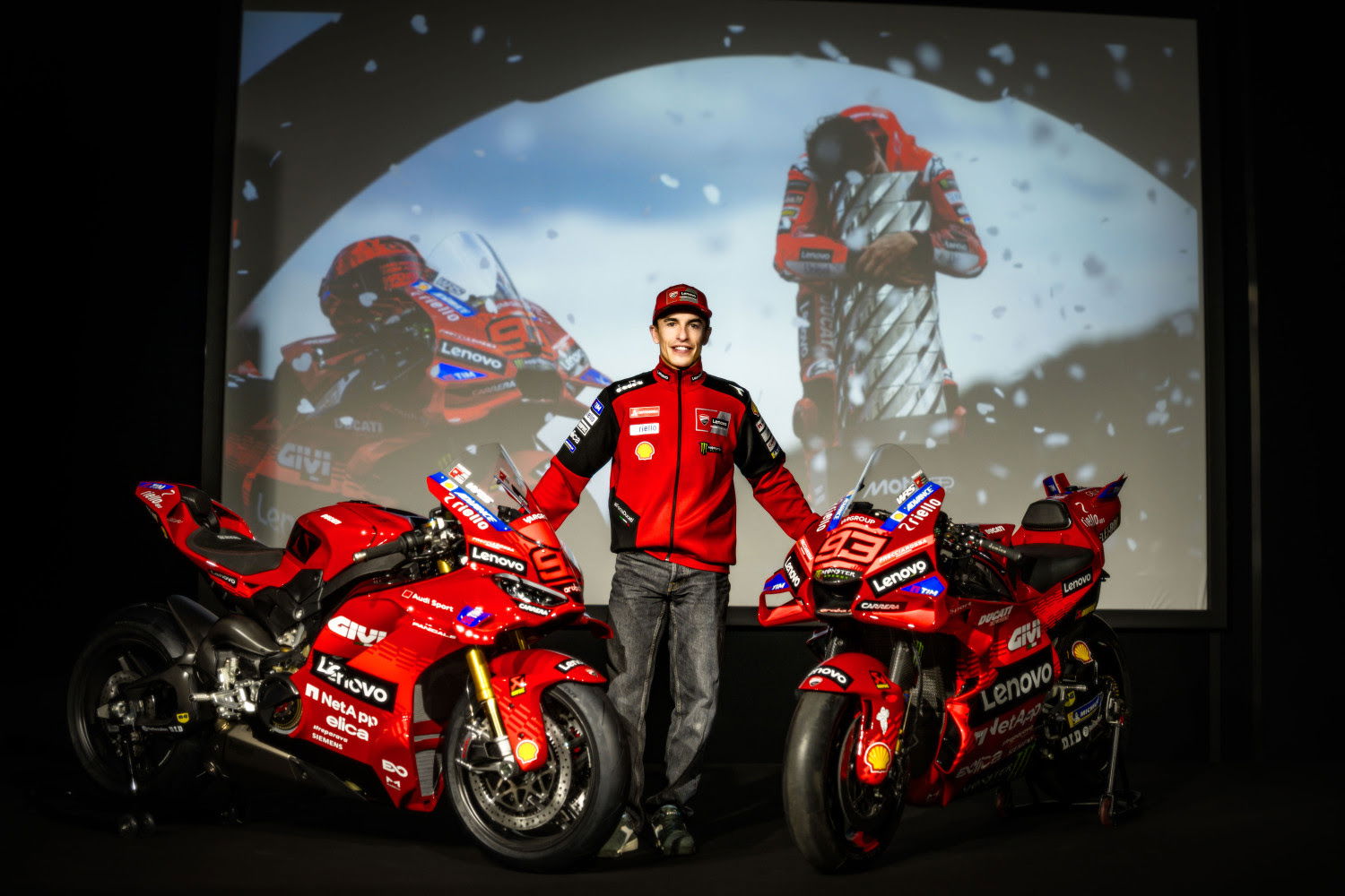 Marc Marquez standing with his MotoGP bike and the Panigale V4 Marquez edition