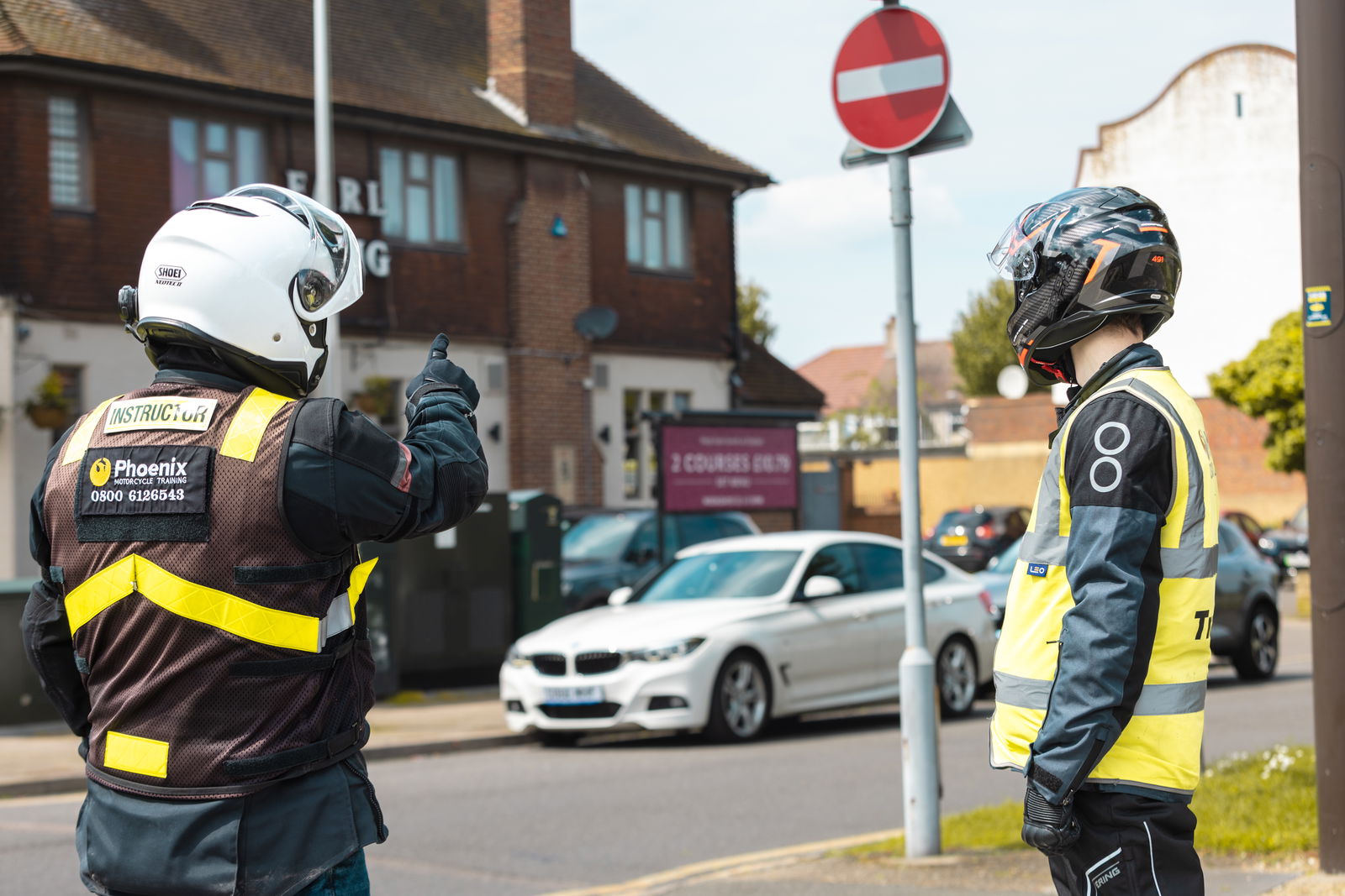 A motorcycle learner talking with an instructor