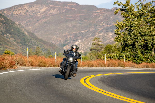 Two motorcycles riding up a mountain road