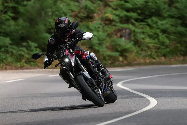 a motorcyclists riding around a corner on a motorcycle