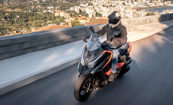 a maxi scooter rides up a mountain road