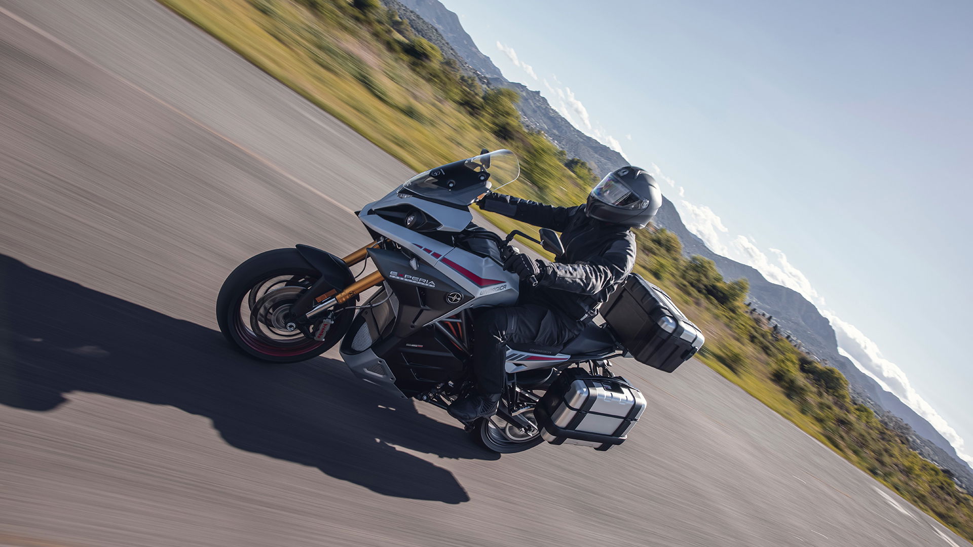 Experia electric sports touring motorcycle ridden on a scenic road