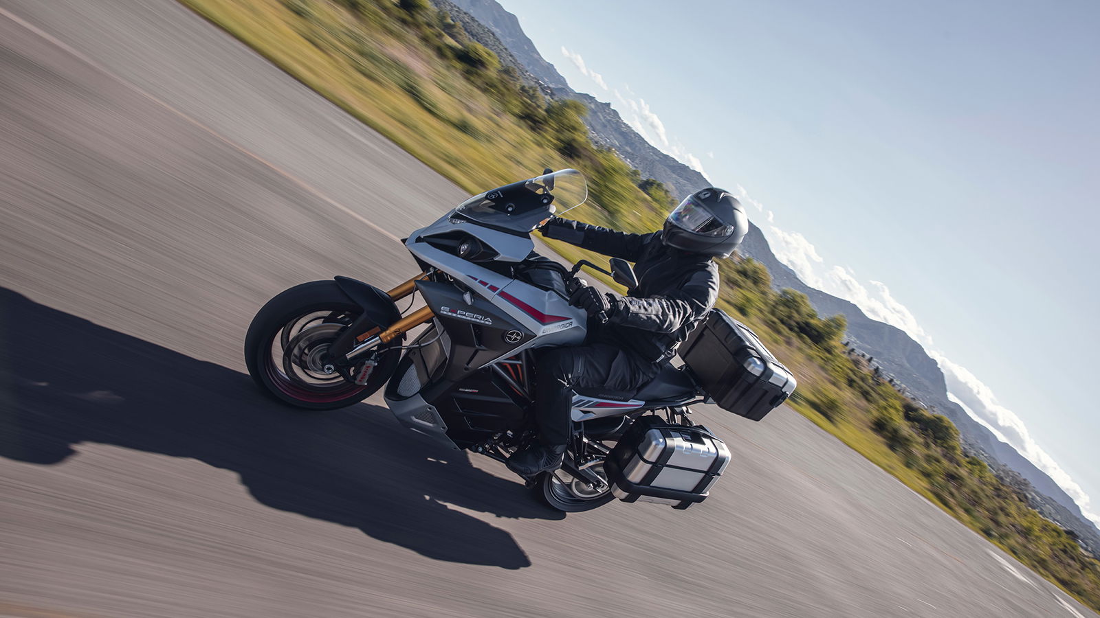 Experia electric sports touring motorcycle ridden on a scenic road