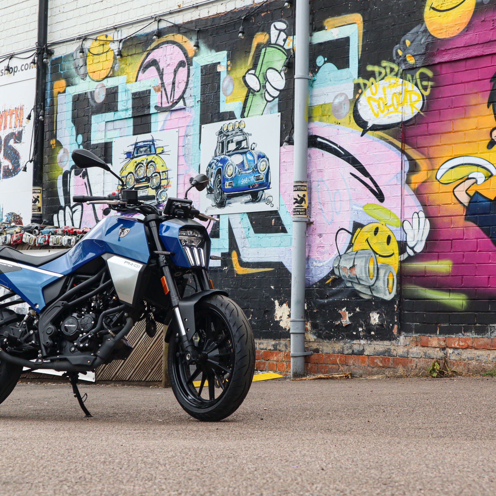 The PM-01 sitting in front of some graffiti on a wall