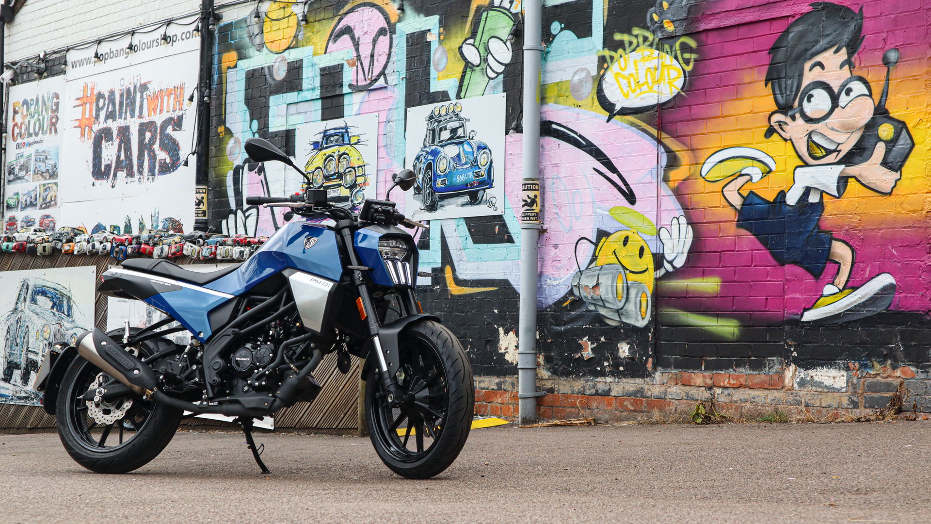 The PM-01 sitting in front of some graffiti on a wall