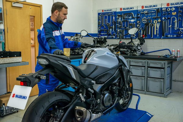 Mechanic servicing Suzuki motorcycle. - Suzuki