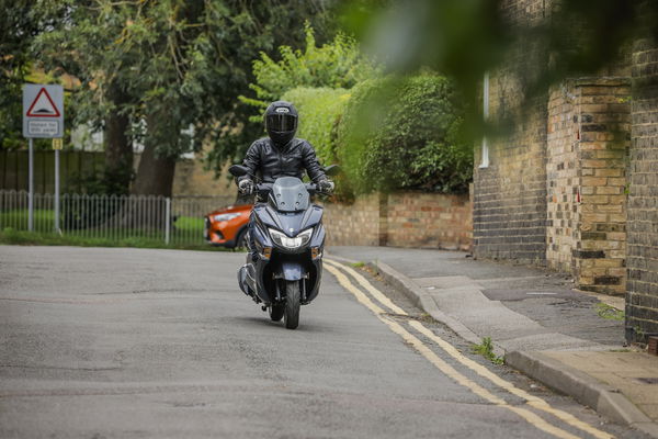 a scooter riding in a town centre