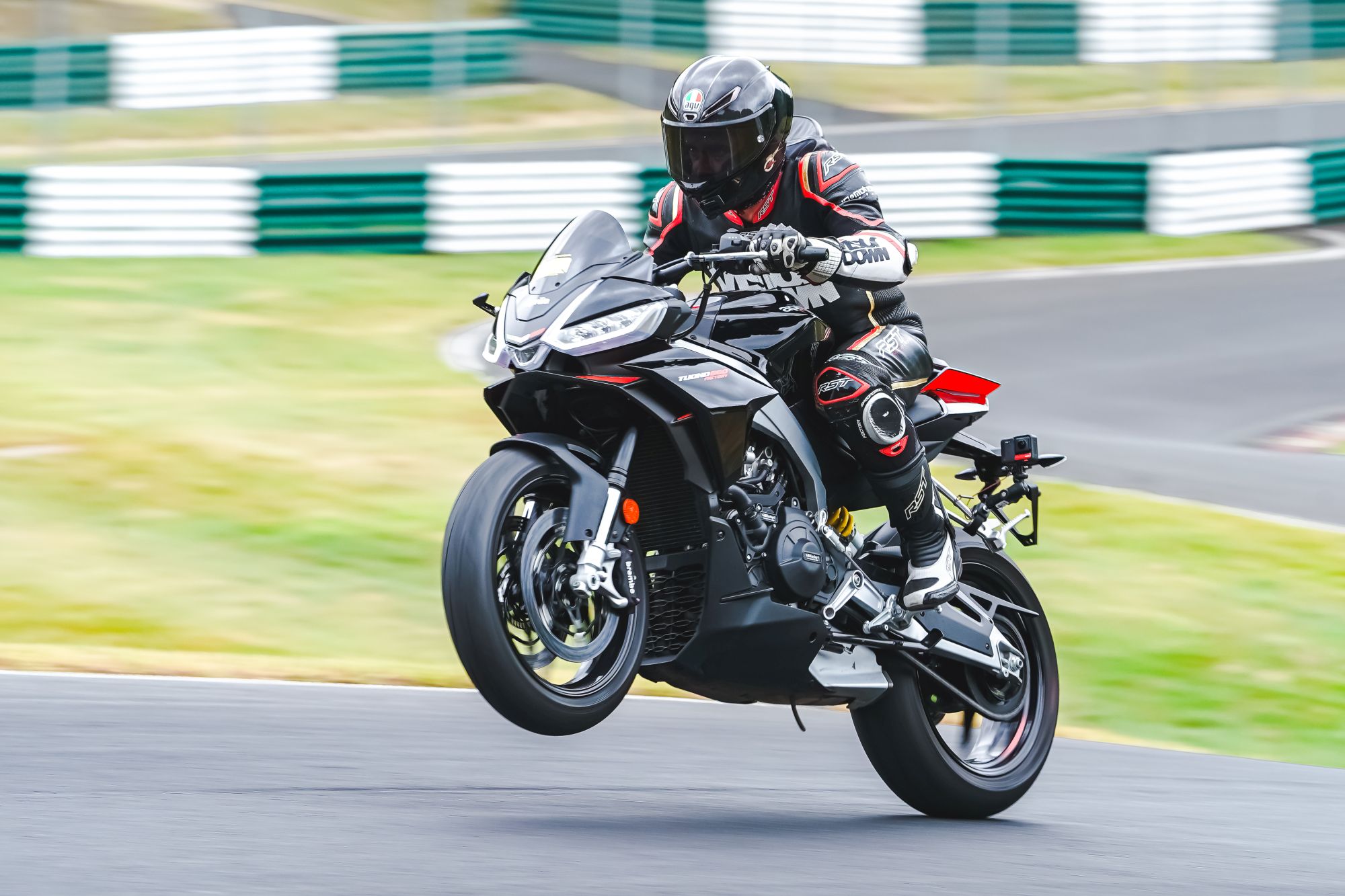 A motorcycle does a wheelie at Cadwell park
