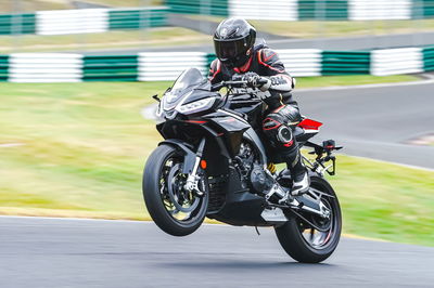 The Tuono 660 Factory wheelies over the mountain at Cadwell Park