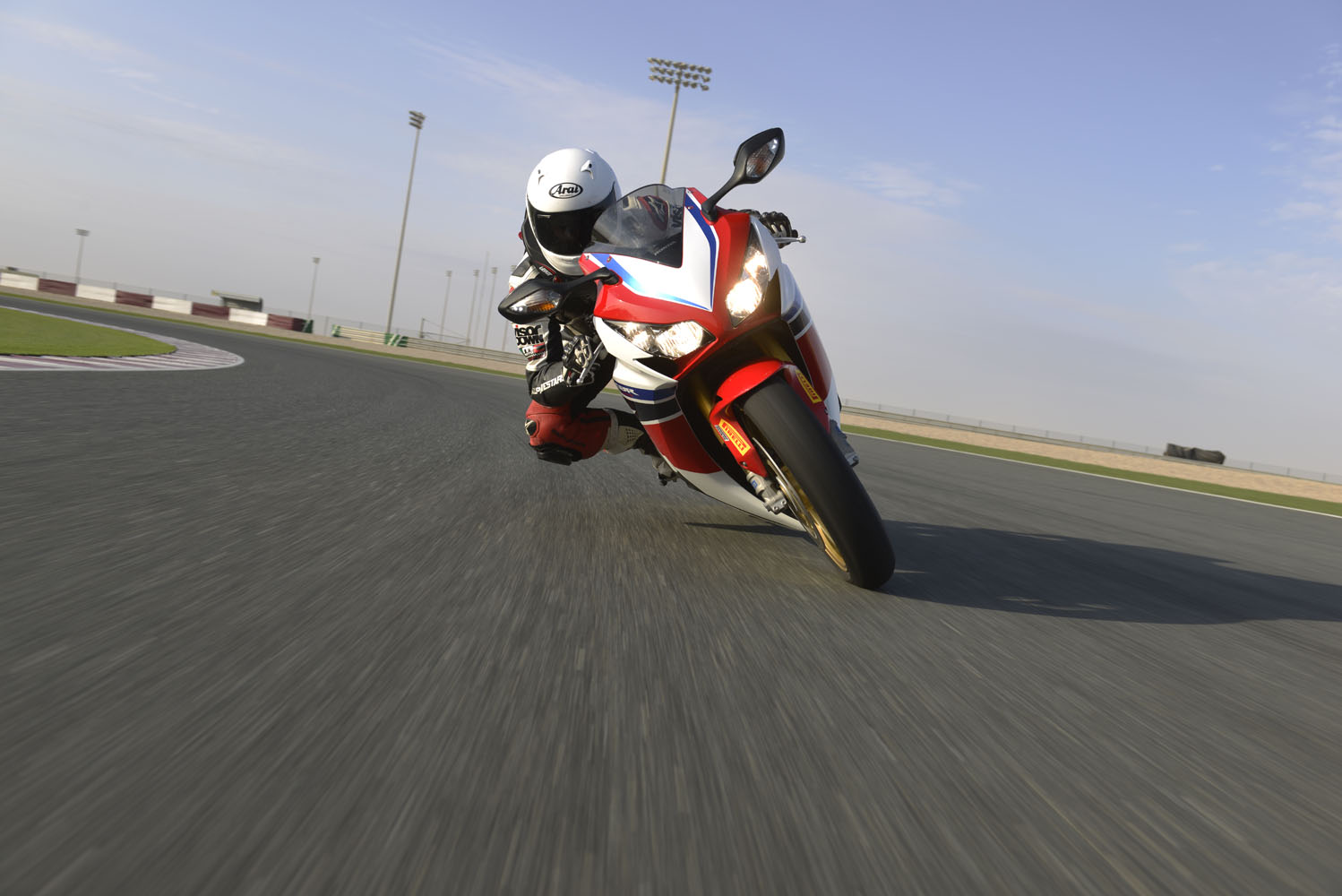 A red, white and blue 2014 Fireblade CBR1000RR-SP being ridden around a racetrack