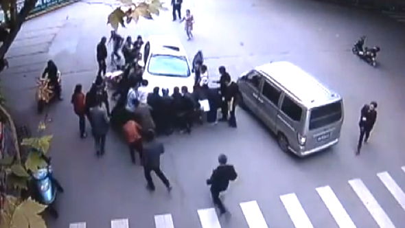 Video: Passers-by lift car off woman after being knocked off scooter