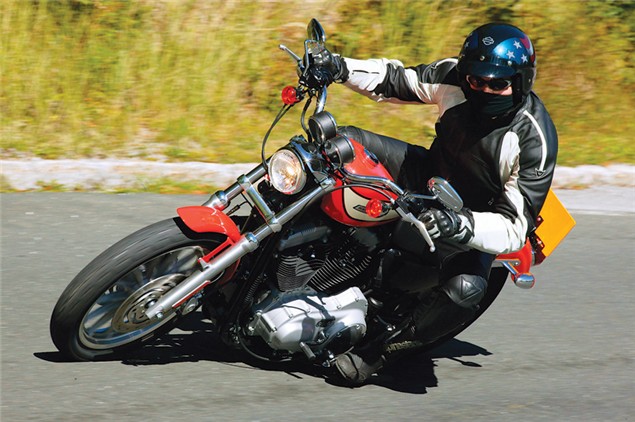 A black and red Harley-Davidson Sportster 2004 being ridden on a track review