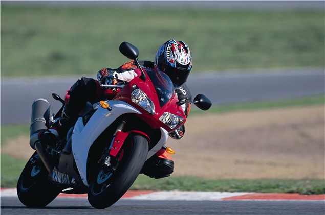A red and white 2002 Yamaha YZF-R1 being ridden on track