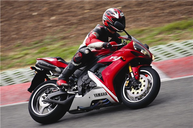 A red 2005-06 Yamaha YZF-R1 being ridden on track