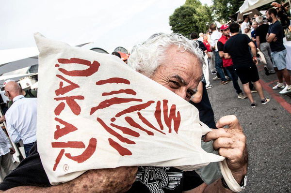 Man holding Dakar-branded flag