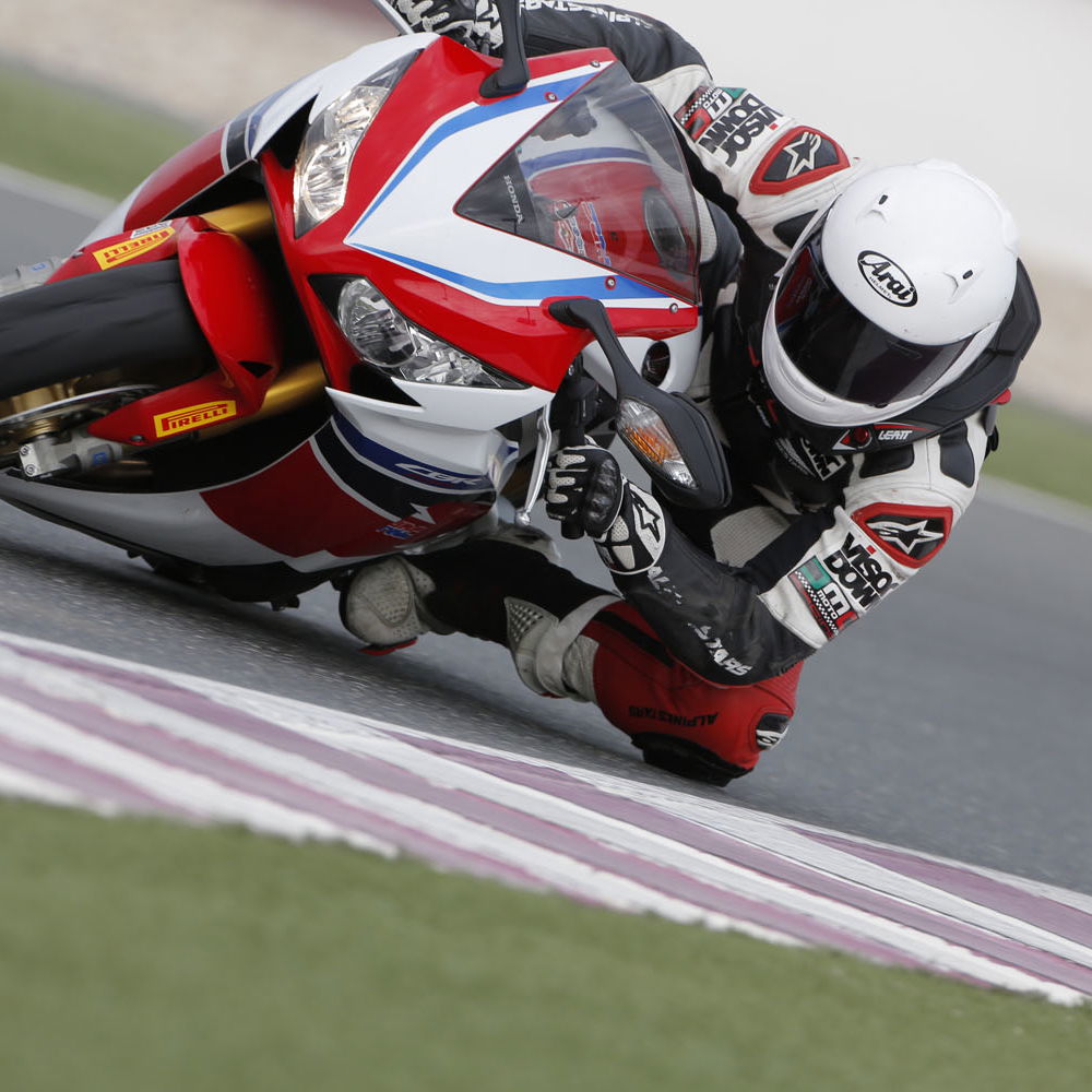 A red, white and blue 2014 Fireblade CBR1000RR-SP being ridden around a racetrack