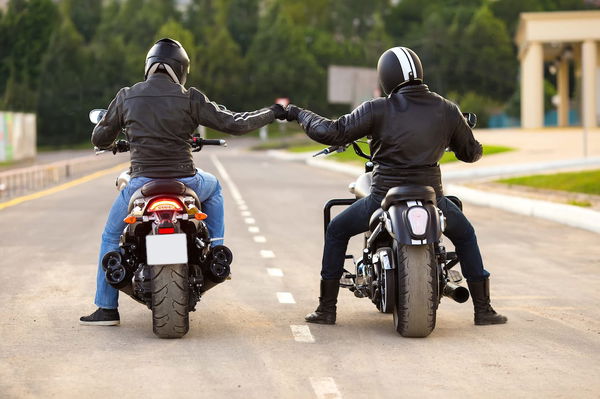 motorcyclist stood next to motorcycle with motorbike helmet