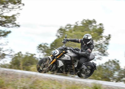 A black, white and gold 2019 Ducati Diavel 1260S being ridden on a country road