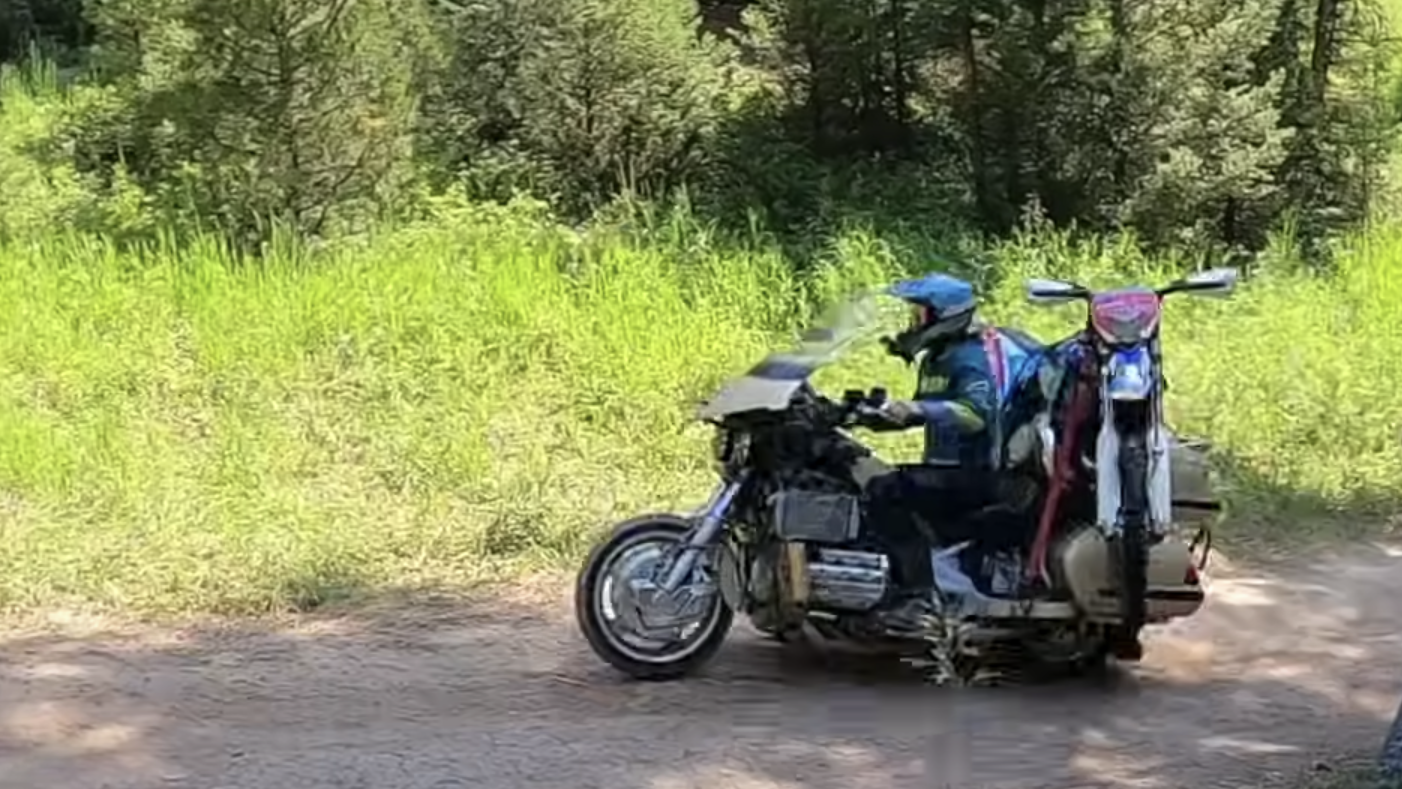 Man takes Honda Gold Wing off-roading with enduro bike strapped on the back