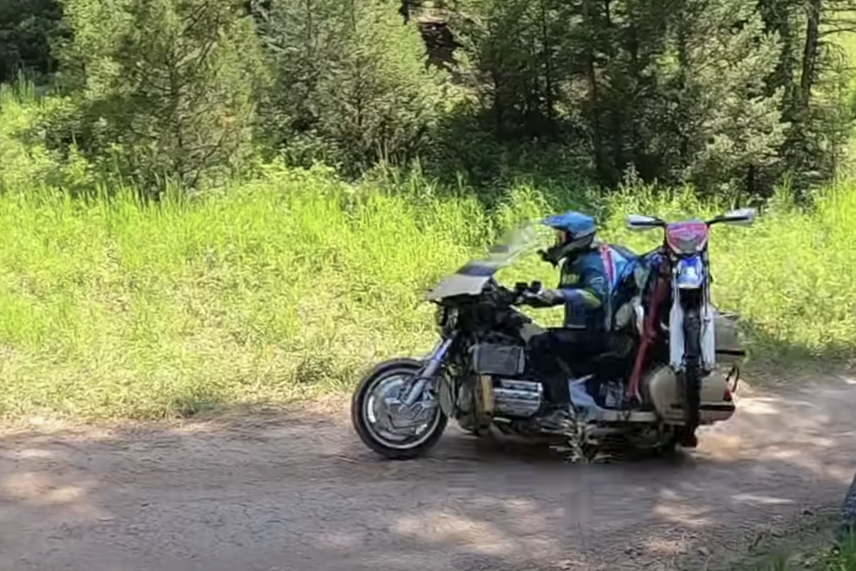 Man takes Honda Gold Wing off-roading with enduro bike strapped on the back