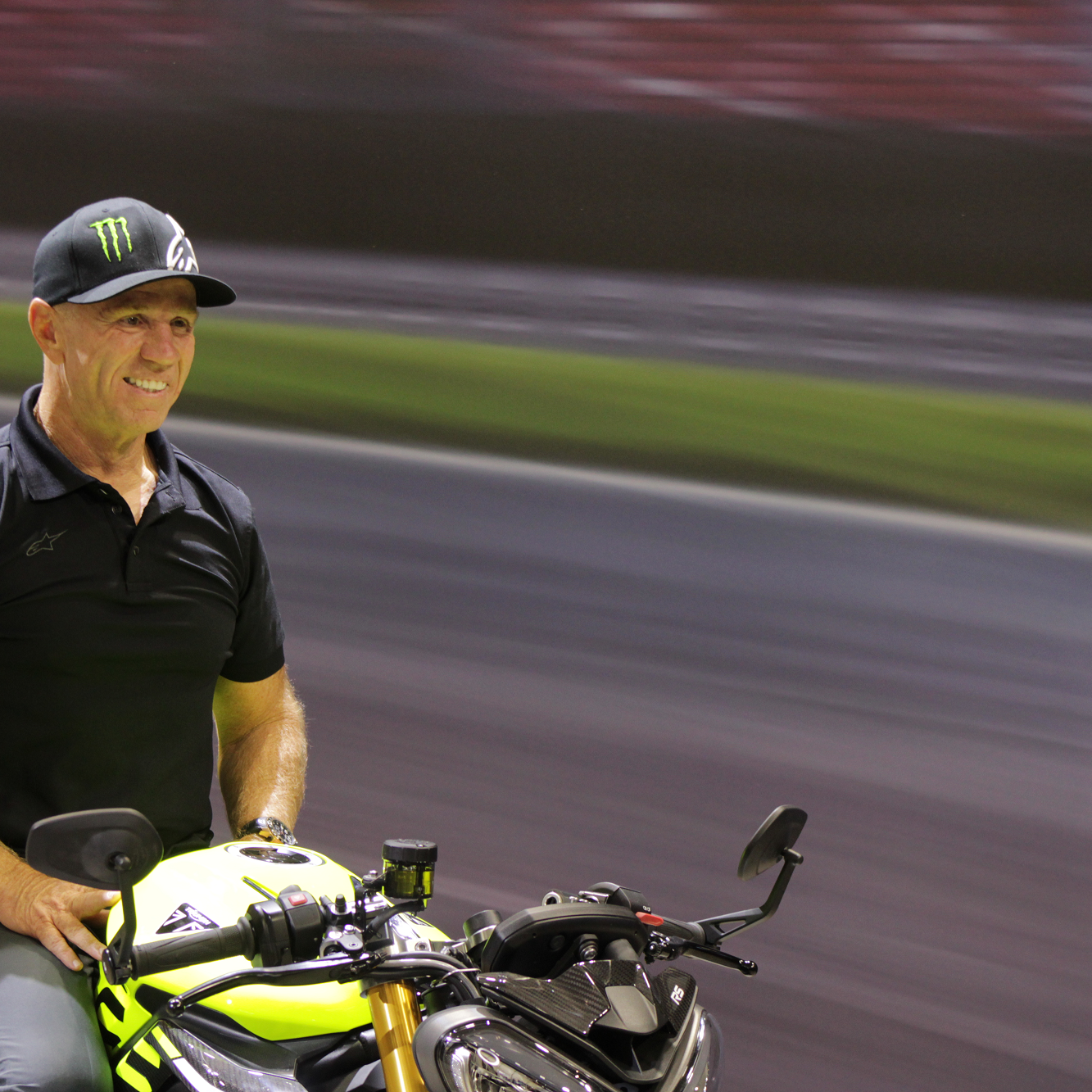 Randy Mamola sitting on Triumph Street Triple 765 Moto2 Edition at Motorcycle Live 2022.