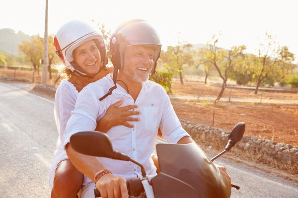 couple riding scooter 