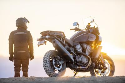 Harley-Davidson Pan America parked in desert, with low sun in background.