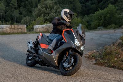 a maxi scooter rides upo a mountain road