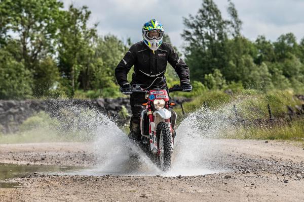 A motorcycle splashing through a puddle