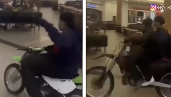 Two dirt bikes being ridden through the mall