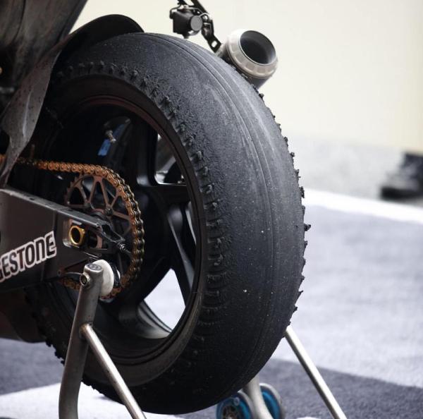 A heavily used wet racing tyre on a MotoGP bike