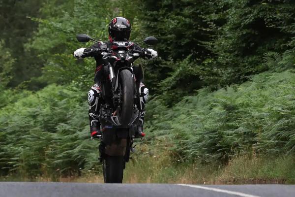 A motorcyclist pulling a wheelie on a motorcycle