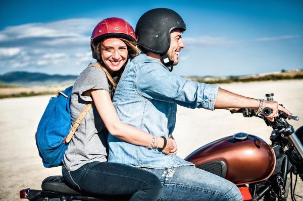 couple riding a motorcycle on the beach