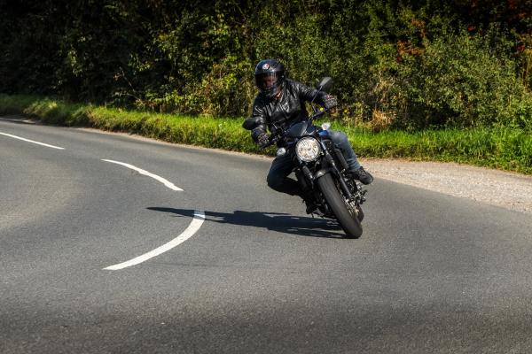 a motorcycle being ridden down a country lane