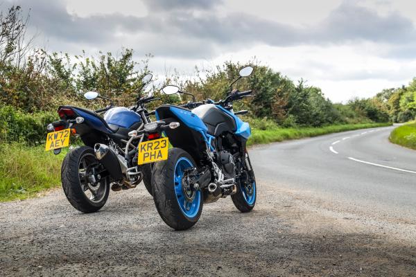 Two motorcycles parked at the side of the road