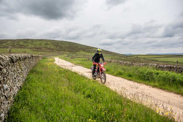 A Honda CRF250L on a green lane